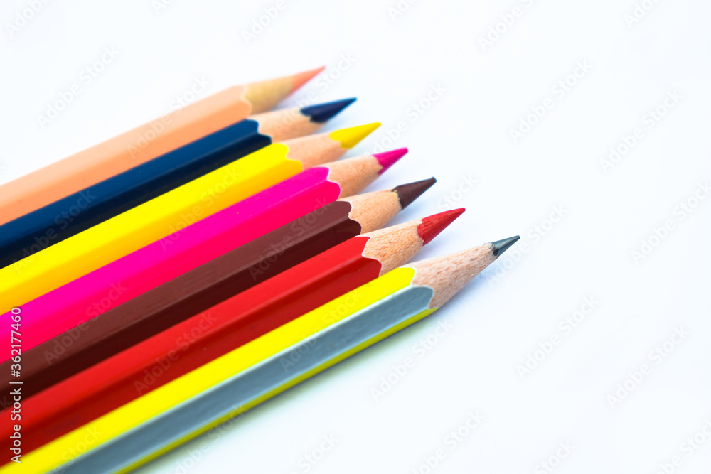 Some different colored wood pencil crayons scattered across a white background Some different colored wood pencil crayons scattered across a white background