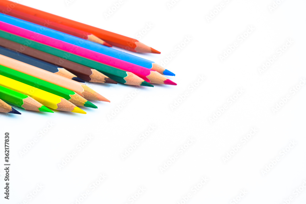 Bunch of different colored wood pencil crayons placed in a pile on a white background Bunch of different colored wood pencil crayons placed in a pile on a white background