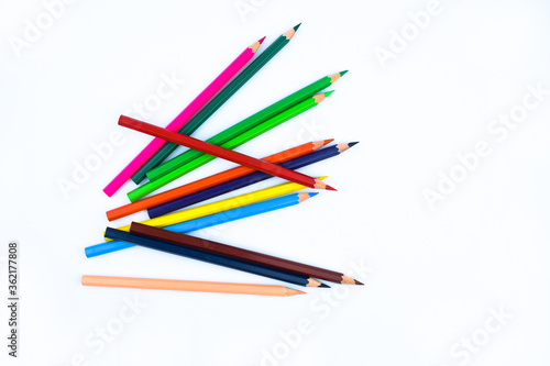 A stack of different colored wood pencil crayons placed on a white paper background