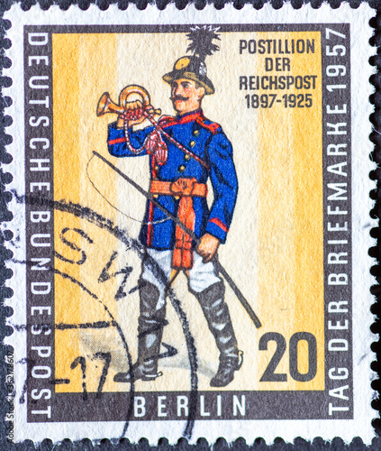 GERMANY, Berlin - CIRCA 1957: a postage stamp from Germany, Berlin showing a postillon of the Reichspost. Day of the postal stamp. photo