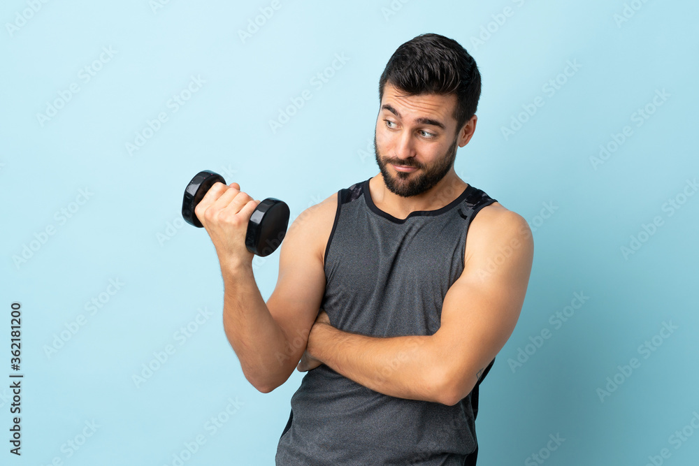 Young sport man with beard making weightlifting with sad expression Young sport man with beard making weightlifting with sad expression