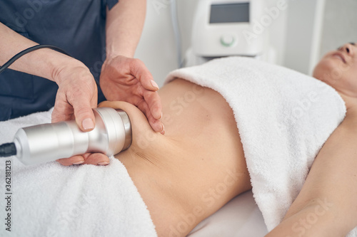 Removing cellulite on abdomen in modern beauty clinic photo