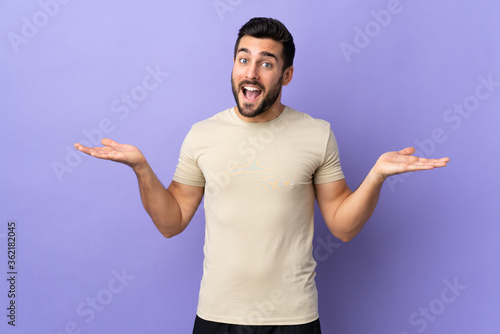 Young handsome man with beard over isolated background with shocked facial expression