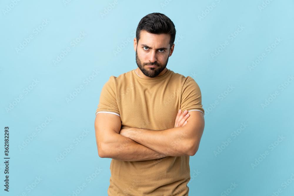 Young handsome man with beard over isolated background with unhappy expression Young handsome man with beard over isolated background with unhappy expression