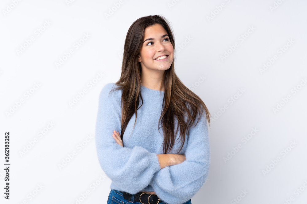 Teenager girl over isolated white background looking up while smiling Teenager girl over isolated white background looking up while smiling