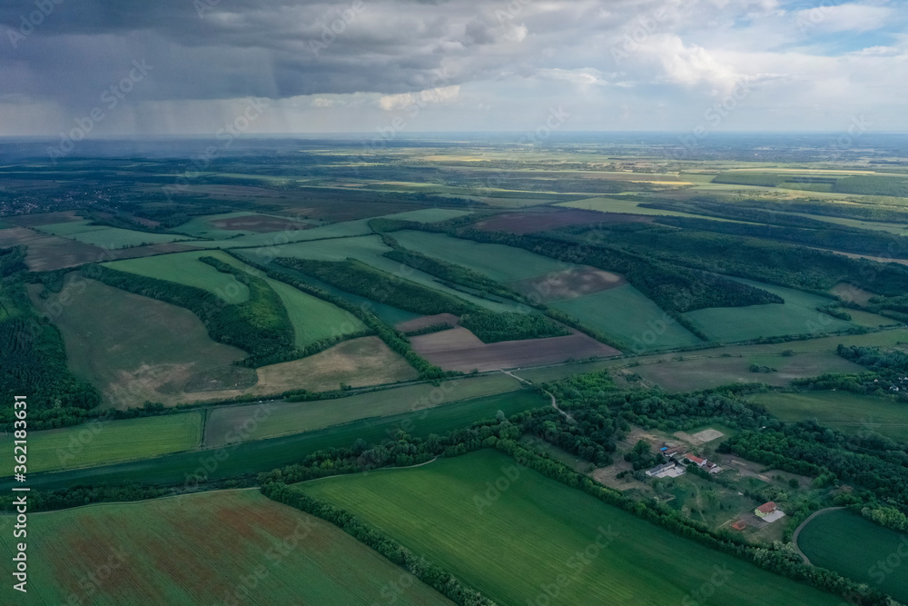 Wheat or barley field under storm cloud. Aerial view from a height. Beautiful landscape.