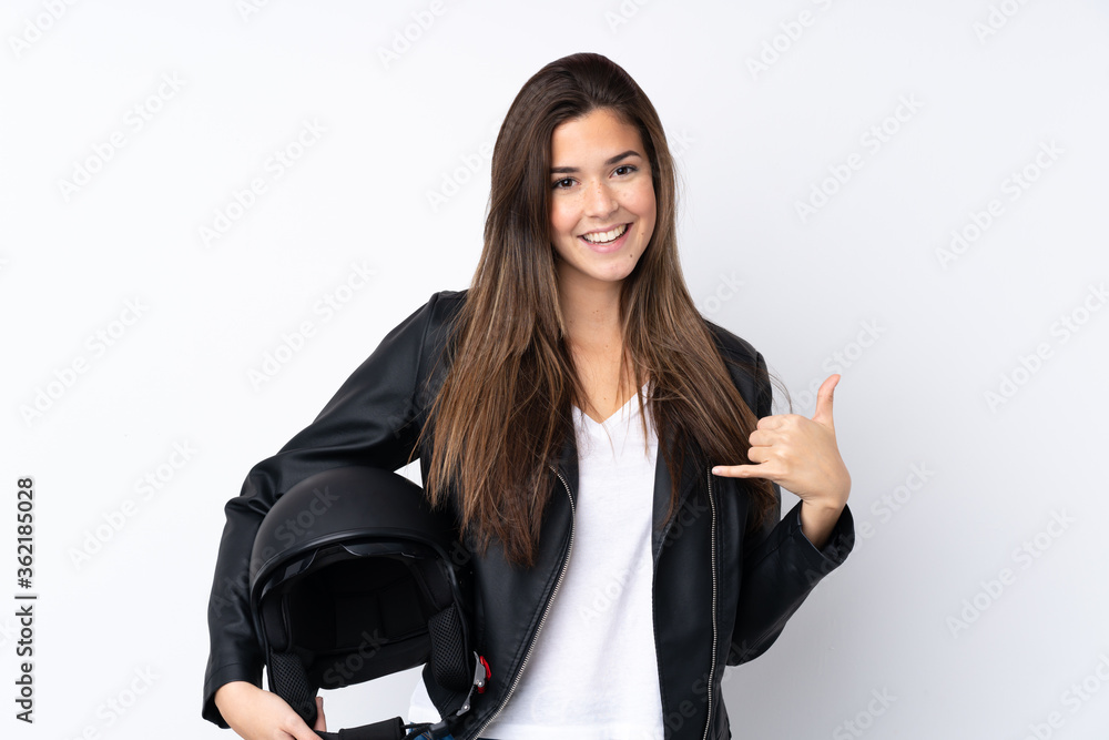 Young woman with a motorcycle helmet over isolated white background making phone gesture Young woman with a motorcycle helmet over isolated white background making phone gesture