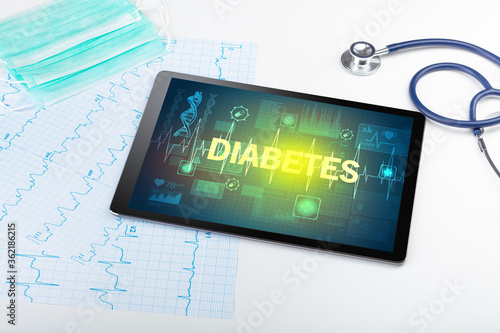 Tablet pc and medical stuff with DIABETES inscription, prevention concept