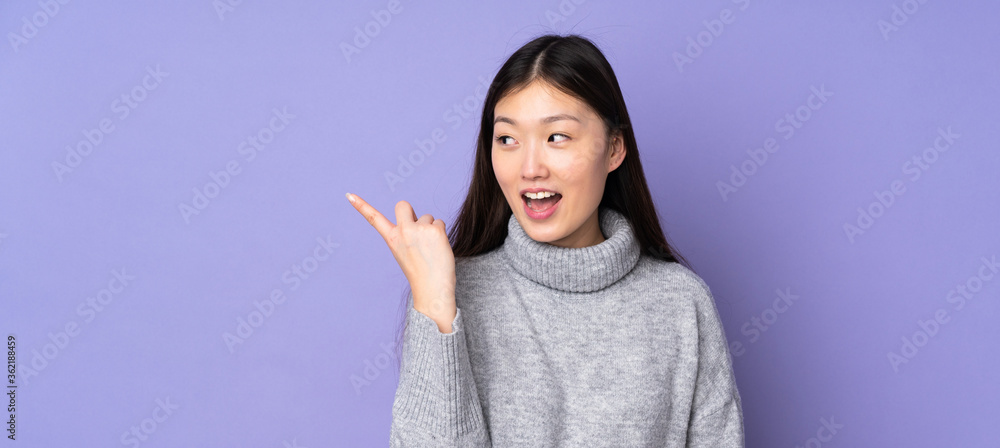 Young asian woman over isolated background intending to realizes the solution while lifting a finger up