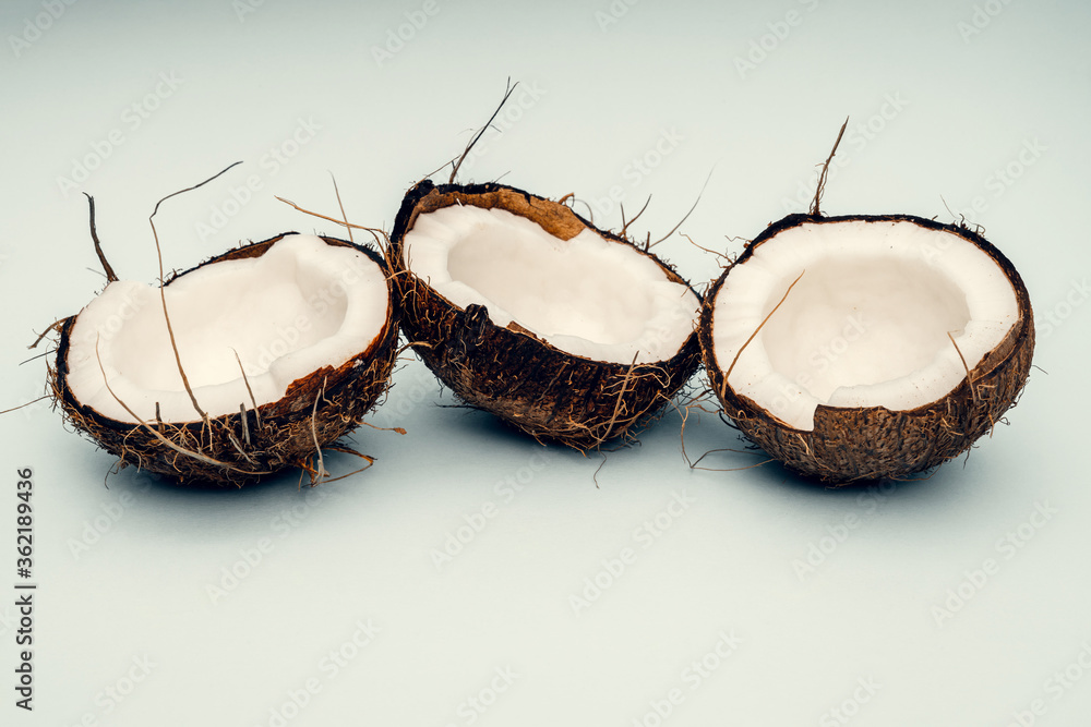 Parts of coconut on a colored background. Close up. Fresh ripe coconut broken into pieces. Parts of coconut on a colored background. Close up. Fresh ripe coconut broken into pieces.