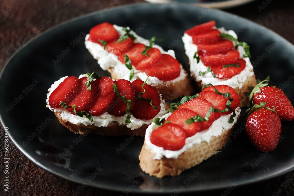 Sandwich with strawberries, soft cheese ricotta and basil. Soft focus.