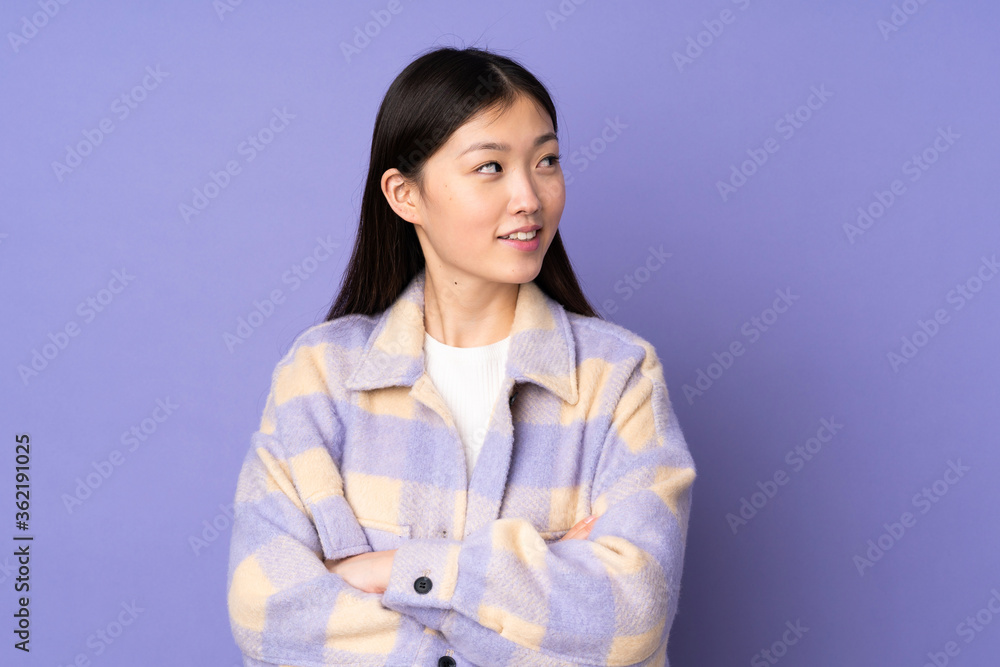 Young asian woman isolated on purple background with arms crossed and happy Young asian woman isolated on purple background with arms crossed and happy