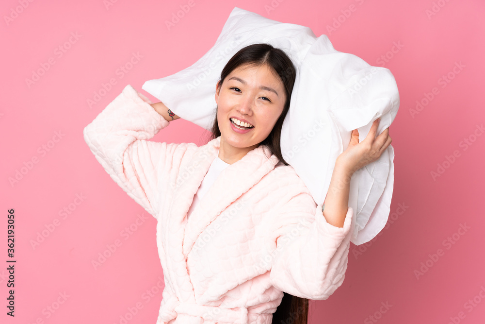 Young Asian woman in pajamas isolated on pink background Young Asian woman in pajamas isolated on pink background