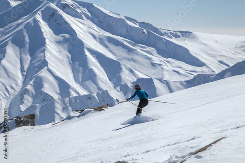Photography A woman skiing downhill on snow covered Himalayan Mountain in Gu