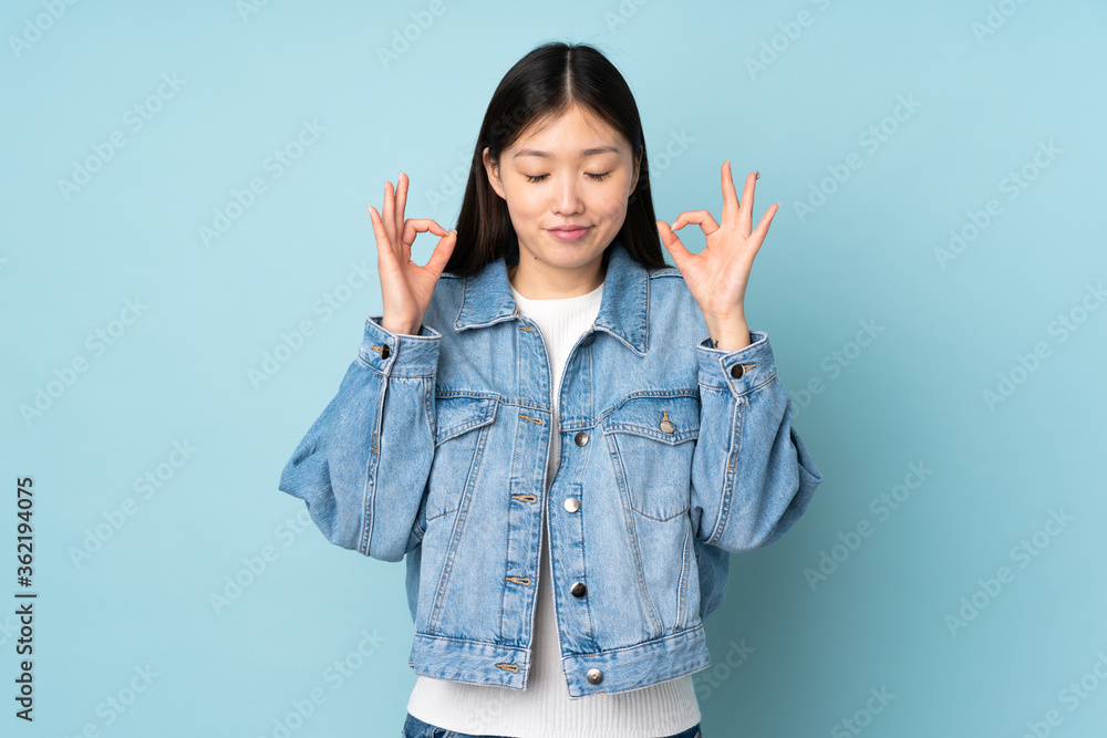 Young asian woman isolated on background in zen pose Young asian woman isolated on background in zen pose