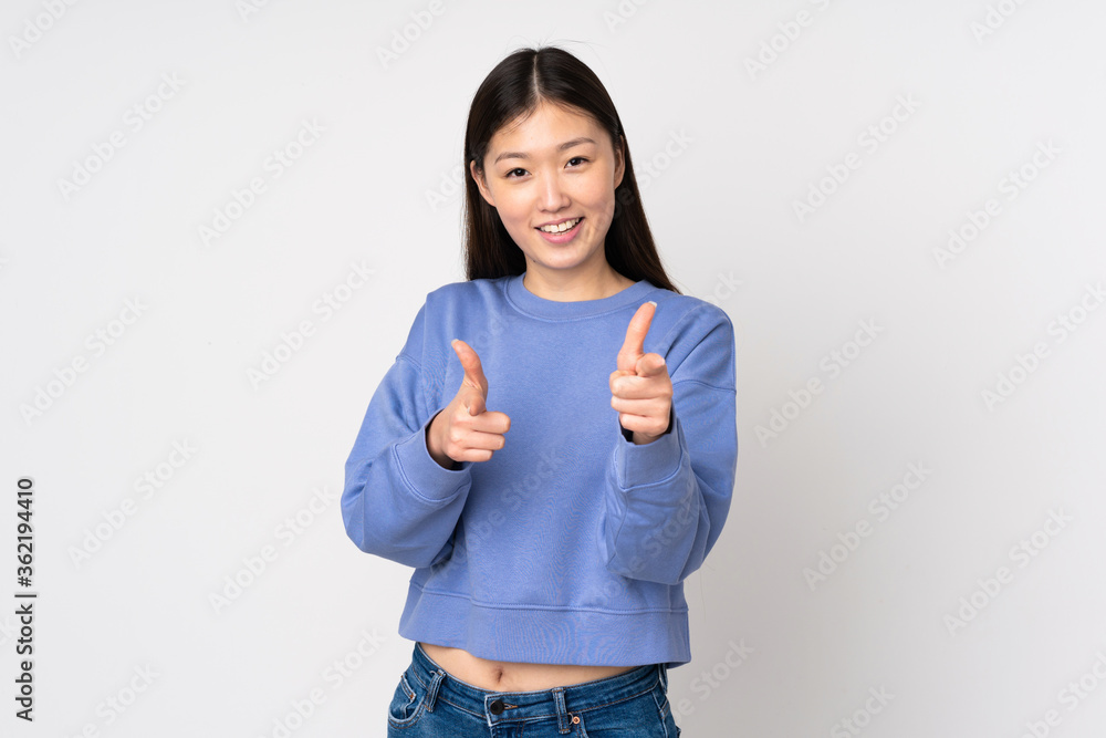 Young asian woman isolated on background pointing to the front and smiling Young asian woman isolated on background pointing to the front and smiling