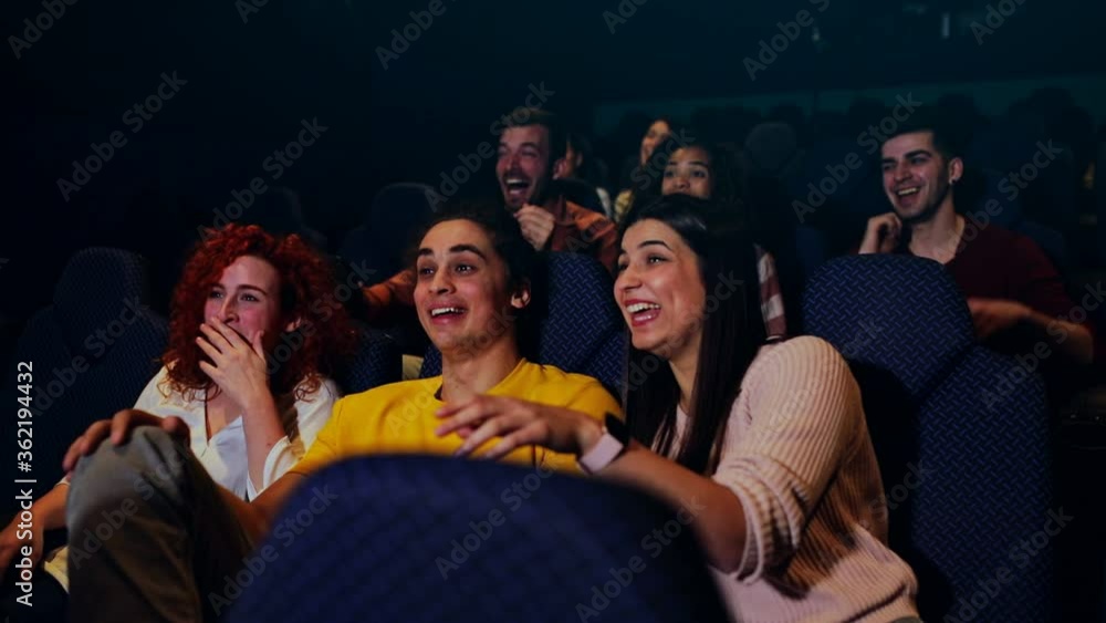 Group of cheerful people laughing while watching movie in cinema. Group of cheerful people laughing while watching movie in cinema.