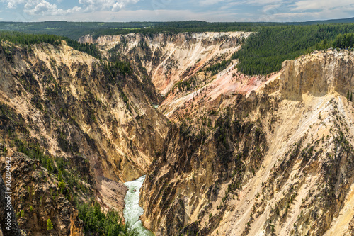 Grand Canyon of the Yellowstone River rushing through a deep cut yellow, pink and brown volcanic rock, Yellowstone National Park