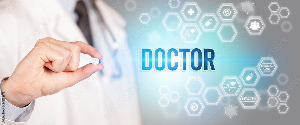 Close-up of a doctor giving you a pill with DOCTOR inscription, medical concept Close-up of a doctor giving you a pill with DOCTOR inscription, medical concept