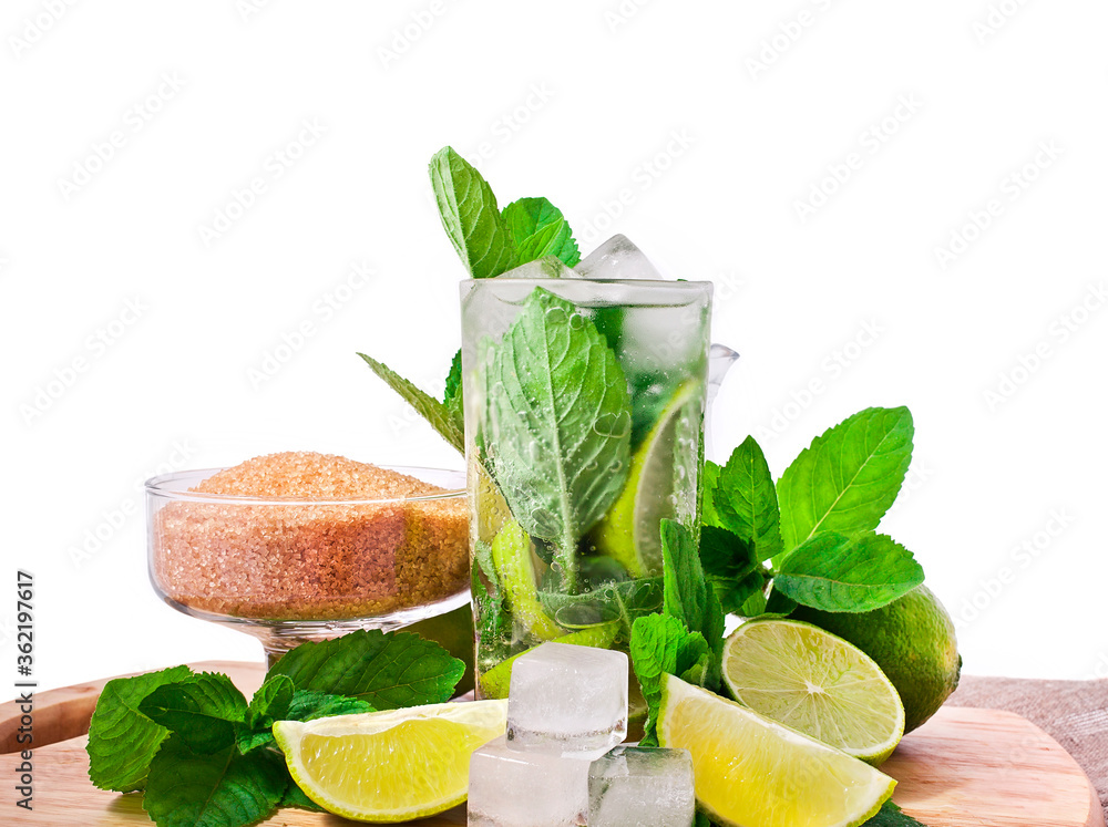 Cocktail mojito with mint leaves, lime and ice on a cutting board isolated on a white background.