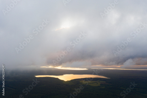 Aerial view clouds over the forest and lake. View from drone. Aerial top view cloudscape. Texture of clouds. View from above. Sunrise or sunset over clouds