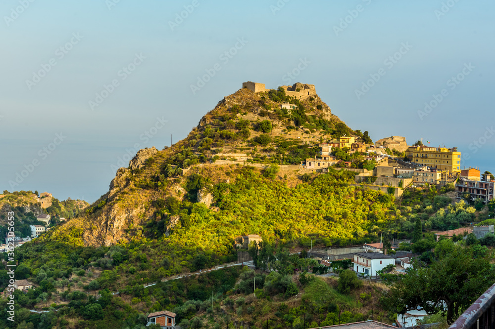 A view of Castelmola on a hilltop above Taormina, Sicily in summer A view of Castelmola on a hilltop above Taormina, Sicily in summer
