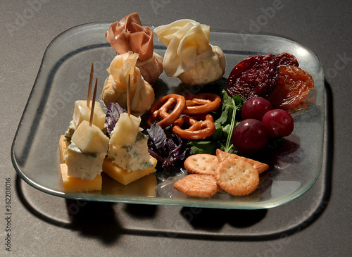 Food design with different kinds of cheese with dried plums, fresh cherries,  bretzels and crackers  