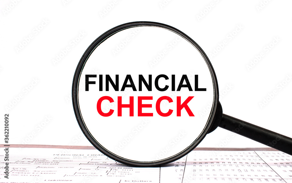 Magnifying glass with text Financial Check on financial tables Magnifying glass with text Financial Check on financial tables
