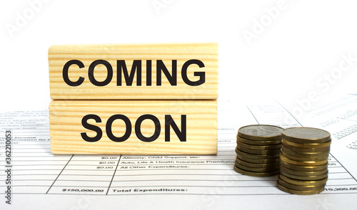 Wooden jenga with text Coming Soon. Finance conzept photo