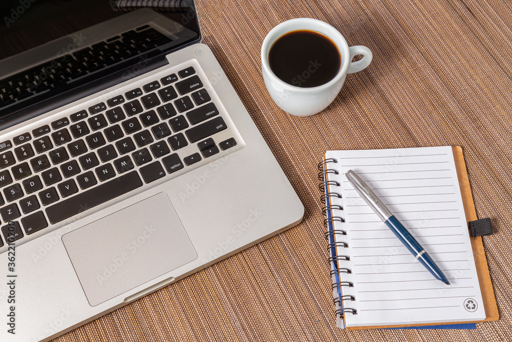 local de trabalho em casa, com bloco de anotações uma caneta um cafe e um laptop local de trabalho em casa, com bloco de anotações uma caneta um cafe e um laptop