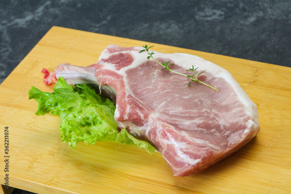 Fototapeta premium Raw pork bone steak over wooden