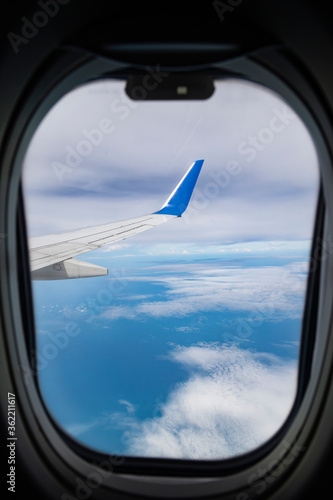 Concept of flying and traveling, view from airplane window on the wing.
