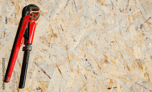 Repair tool. Red gas adjustable wrench on a wooden surface, free space for text, top view