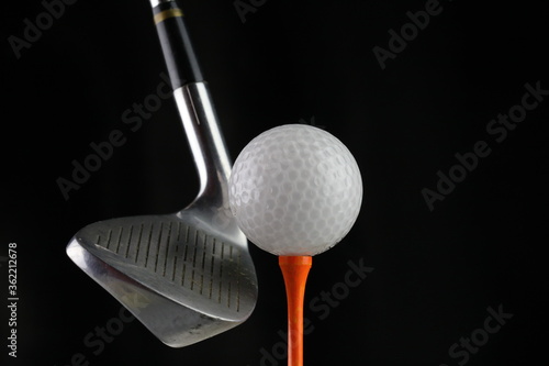 Photo of a golf iron club behind the ball on the fairway