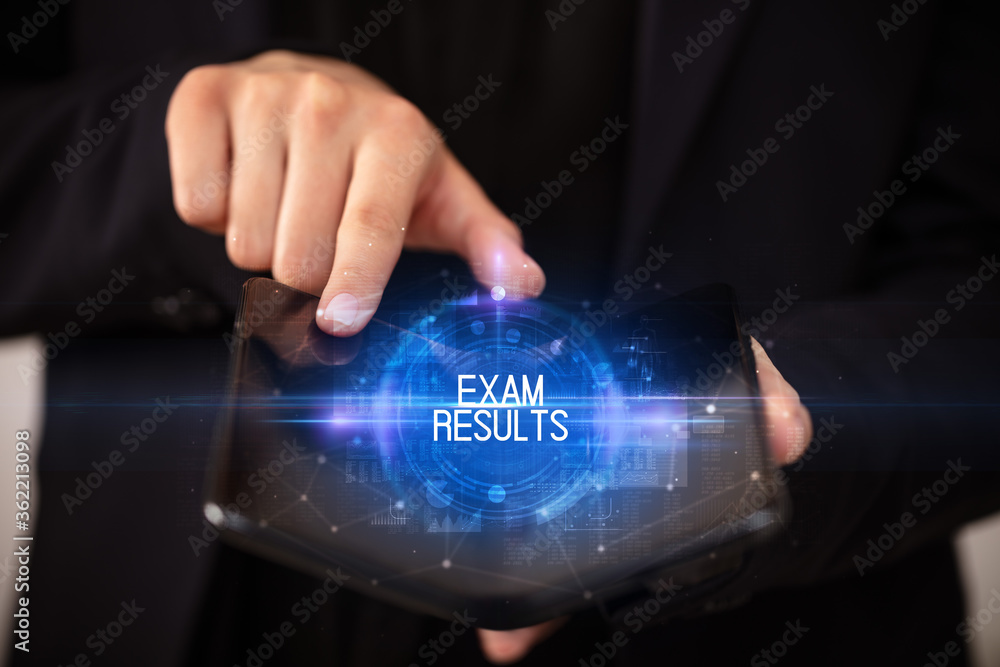 Naklejka premium Young man holding a foldable smartphone with EXAM RESULTS inscription, educational concept