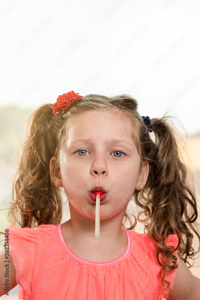 cute little girl holding a lollipop in her mouth cute little girl holding a lollipop in her mouth