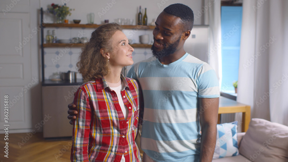 Obraz premium Portrait of smiling cheerful man and woman in love in modern aparnmtent