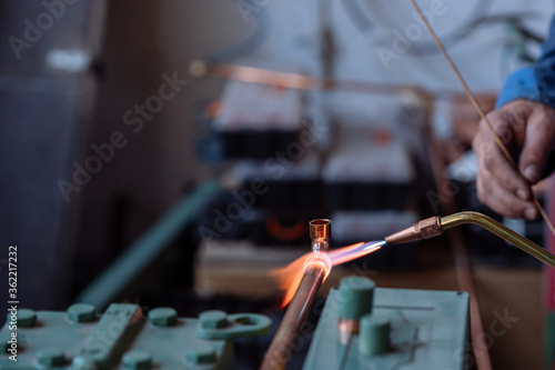 Flame of a copper welding machine heats a copper pipe in a workshop