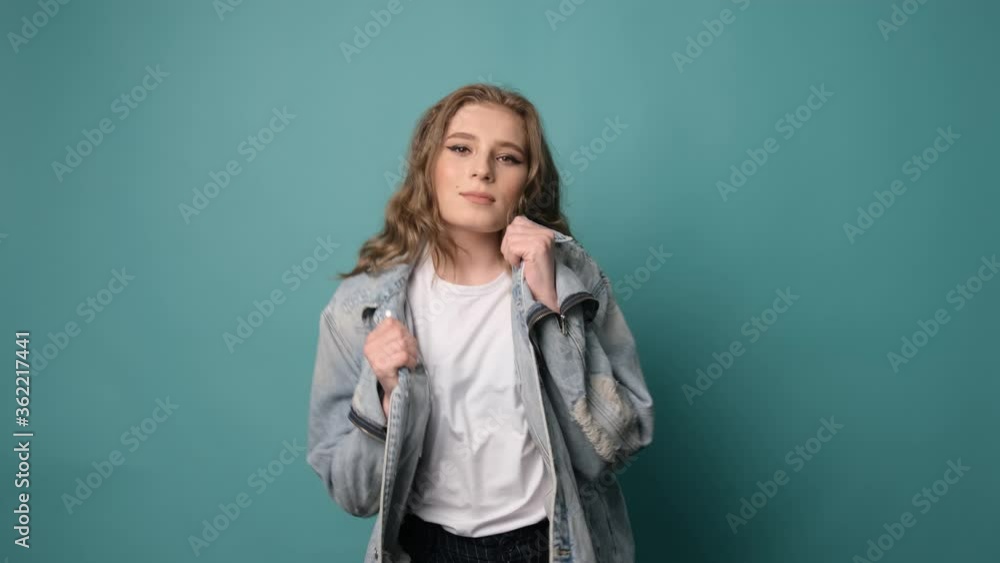 Attractive girl with curly hair dancing and having fun over turquoise background. Positive mood. Attractive girl with curly hair dancing and having fun over turquoise background. Positive mood.