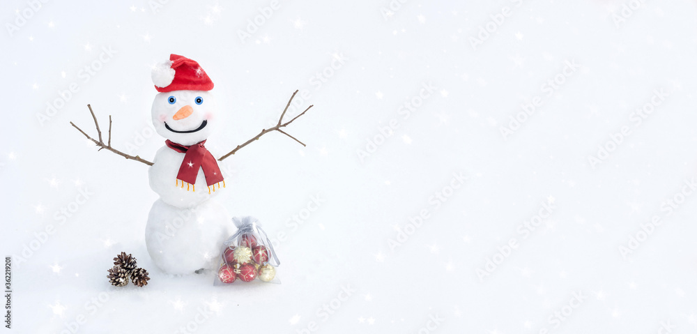 Christmas and New Year banner background with copy space. Snowman in Santa's red hat and scarf on the snow with Christmas balls. Winter card.