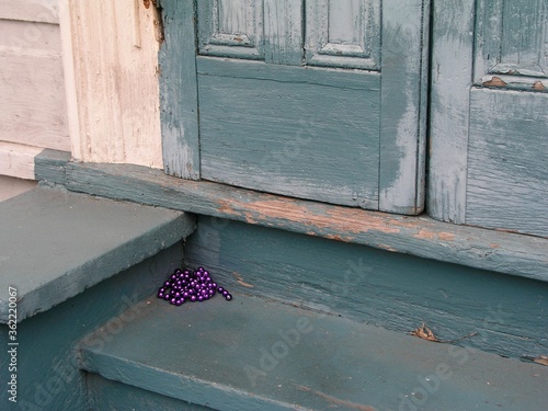 Closeup shot of purple Mardis Gras beads on stairs near a front door in New Orleans, Louisiana, USA photo