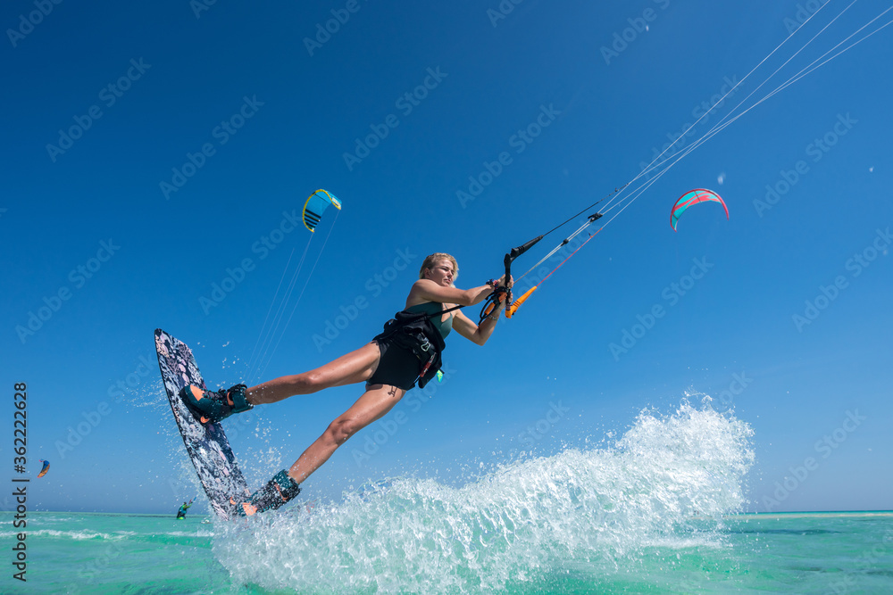 Kite girl rides in the ocean clear water