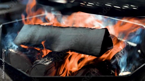 Wood burning at campfire, smoke flowing between the logs. Footage captured with full frame camera and shallow depth of field