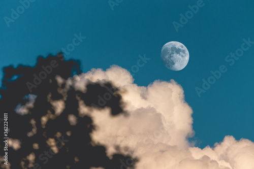 Evening sky with clouds and bright partial moon. Nightsky with large moon, nature background