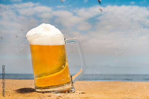 fresh beer mug on the beach with seagulls flying