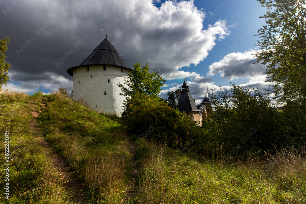 The tower and the defensive walls around the Pskov-Pechersk Assumption Orthodox Church and Cathedral. Landscape of a historic building