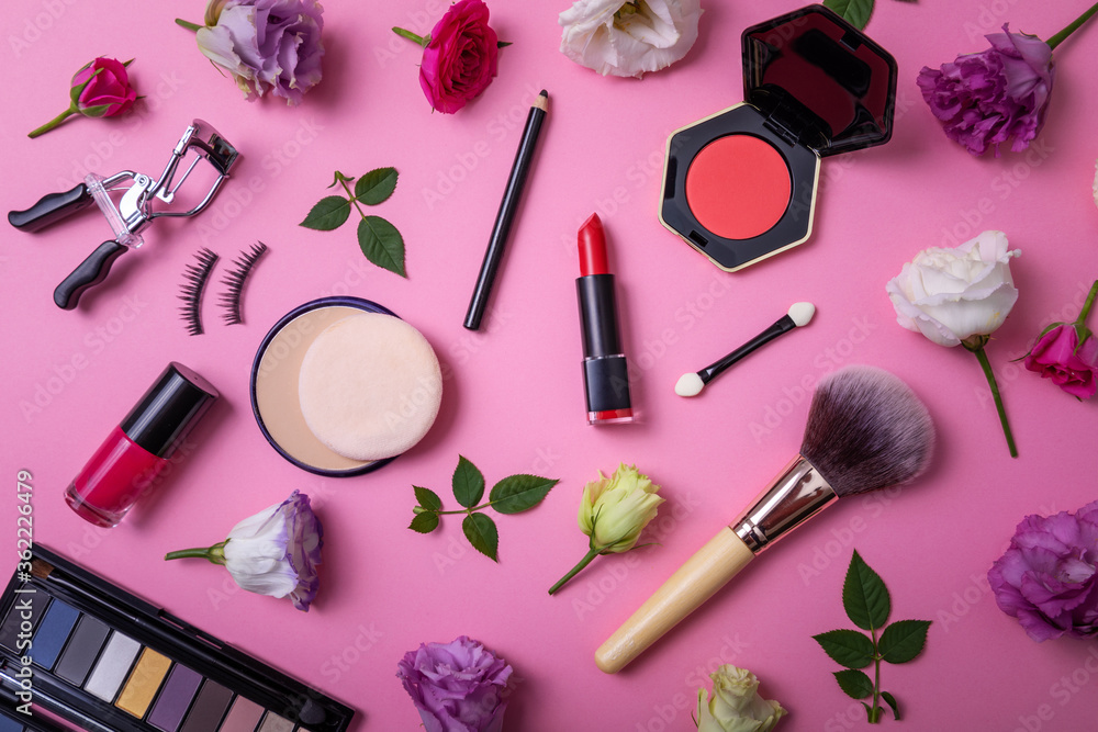 makeup cosmetics and equipment with flowers on pink background