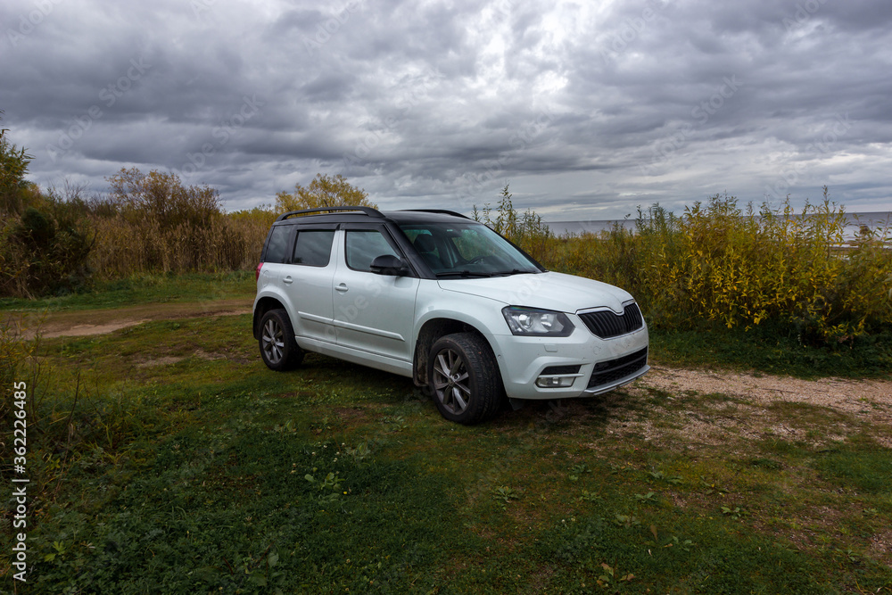 Universal white crossover car parked for travelers on the territories of coastal reserves in the Pskov region, west of the Izborsk Valley, Russia. Fishing, Hunting and Tourism Universal white crossover car parked for travelers on the territories of coastal reserves in the Pskov region, west of the Izborsk Valley, Russia. Fishing, Hunting and Tourism