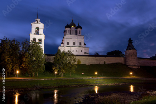 View of the night Pskov Kremlin near the city river on a summer clear day. Beautiful purple sunset over the cityscape.