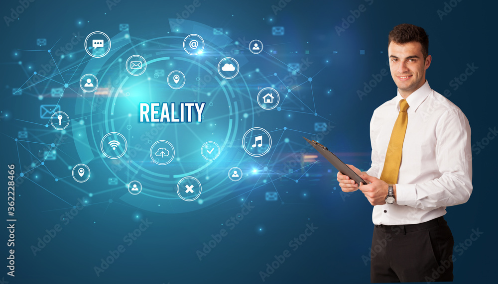 Businessman thinking in front of technology related icons and REALITY inscription, modern technology concept Businessman thinking in front of technology related icons and REALITY inscription, modern technology concept